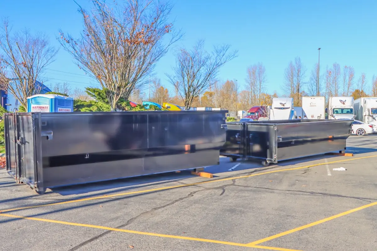 Professional dumpster rental service with roll-off container on residential driveway in Provo